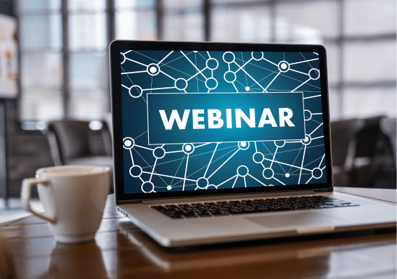 Laptop with Webinar on screen with coffee mug sitting next to it