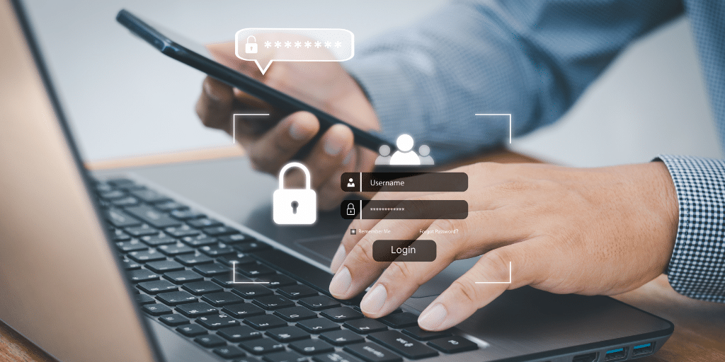 Person typing on a laptop while holding a phone. Representing 2 factor authentication.