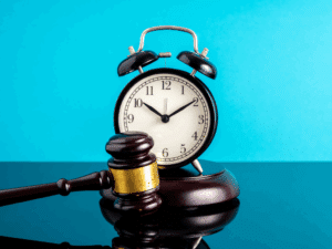 Image of a clock with a gavel in front of it. Turquoise background