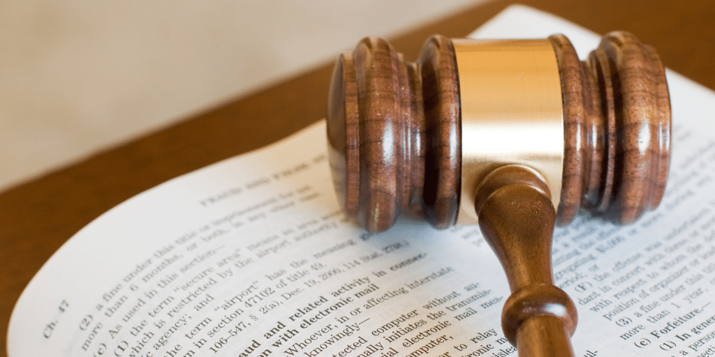 Open book with a gavel laying on top of the book.