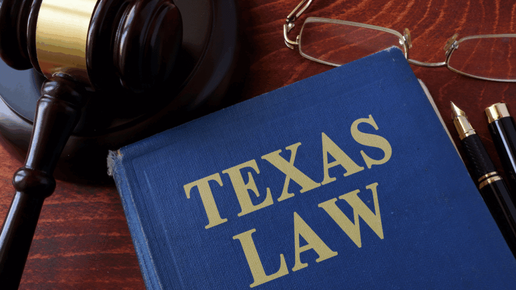 Image of a blue book that says "Texas Law" with a gavel sitting off to the left and a pair of reading glasses to the right of the book.